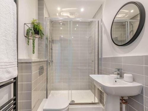 a bathroom with a shower and a sink and a mirror at Peasgood in Spilsby