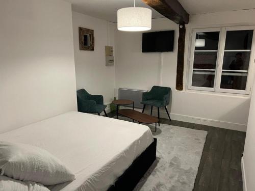 une chambre avec un lit et deux chaises et une fenêtre dans l'établissement Ouly, à Honfleur