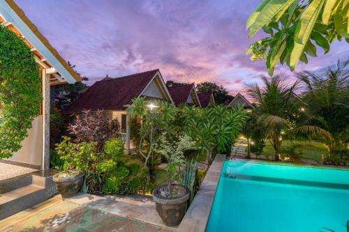 a house with a swimming pool in front of a house at Le Biu garden View in Nusa Lembongan