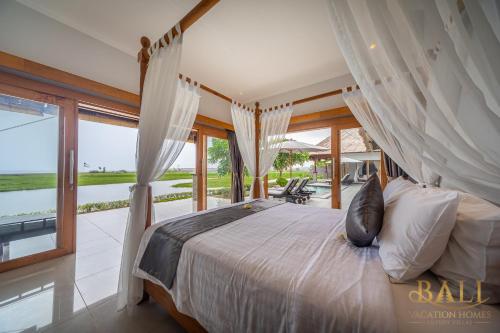 1 dormitorio con cama y ventana grande en DeLuxe 2BR Villa + Private pool + Sawa view!, en Tegallengah