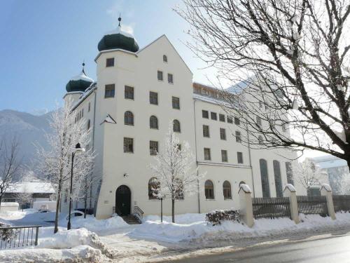 un gran edificio blanco con nieve en el suelo en Kampenwand-Loft, en Aschau im Chiemgau