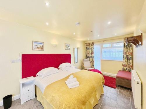 um quarto com uma cama grande e uma cabeceira vermelha em Accessible Couple Friendly Home Pass The Keys em Sketty