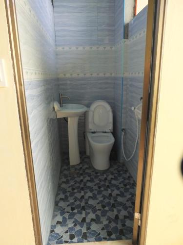 a small bathroom with a toilet and a sink at YahVilla Homestay in Baguio