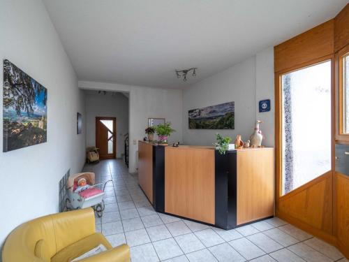 a living room with a yellow chair and a cabinet at Gästehaus Marion in Dettingen an der Erms