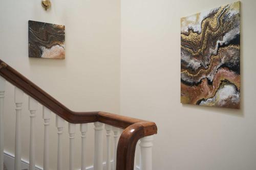 two pieces of art on a wall next to a staircase at The White Hart Hotel in Modbury