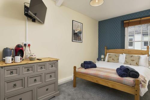 a bedroom with a wooden bed and a dresser at The White Hart Hotel in Modbury