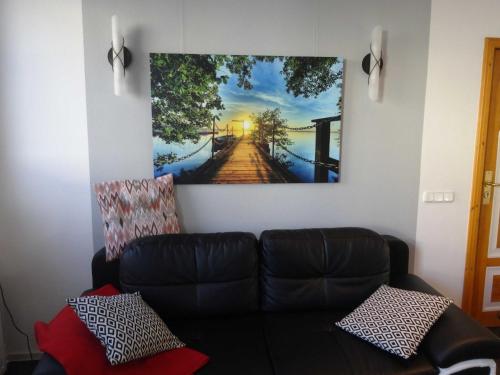 a living room with a couch and a painting on the wall at Ferienwohnungen Haus Leonore in Stendal