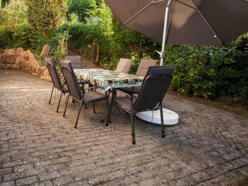 - une table avec des chaises et un parasol sur la terrasse dans l'établissement Haus Karle, à Ettenheim