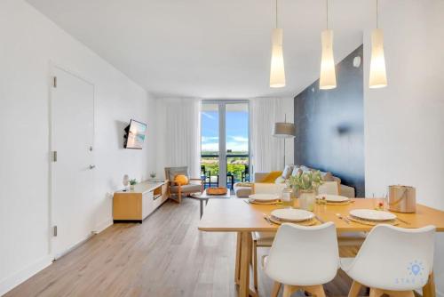 a dining room and living room with a table and chairs at Spectacular Balcony - Near Beach - Gym - Pool in Hallandale Beach