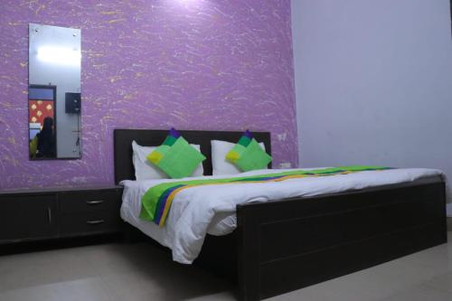 a bedroom with a bed with a purple wall at Hotel diamond tree by dream homes group in Agra