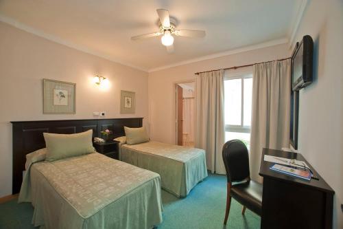 Habitación de hotel con 2 camas y ventana en Hotel Esmeralda Select en Mar del Plata