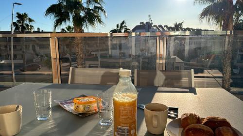 a table with a bottle of orange juice and bread at Casa Virginia in Los Alcázares