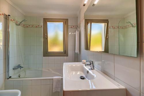 a white bathroom with a sink and a bath tub at Beach Villa Can Carles by Sealand Villas in Port de Pollensa