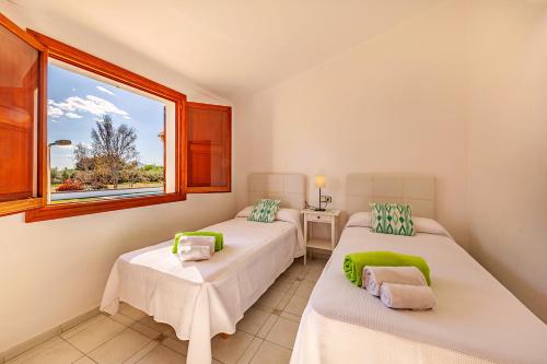 two beds in a room with a window at Beach Villa Can Carles by Sealand Villas in Port de Pollensa