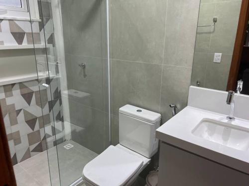 a bathroom with a toilet and a shower and a sink at Casa 05 suítes, piscina e natureza in Mata de Sao Joao