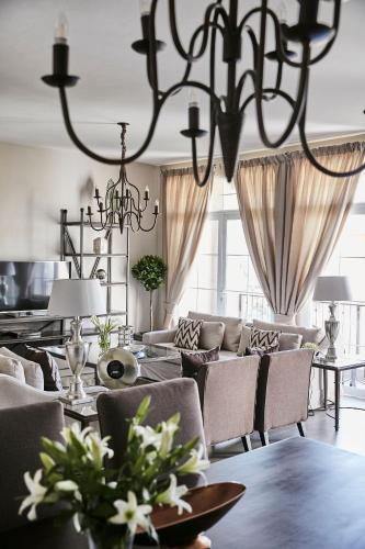 a dining room with a table and chairs and a chandelier at Palacina The Residence & The Suites in Nairobi
