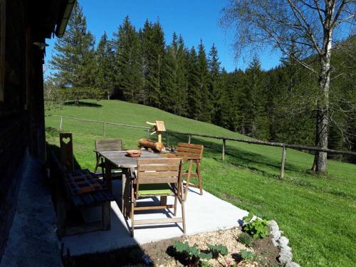 a wooden table and chairs sitting on a patio at Wildererhütte 240 Jahre alt 