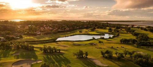 an aerial view of a golf course with a pond at Golden hour retreat lagoon view villa with pool in Palazzo Vianello