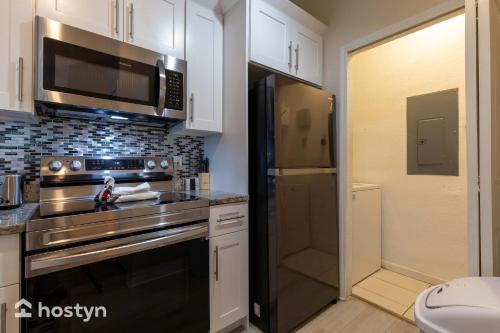 a kitchen with a stove and a microwave at Incredible apartment just 15 minutes from Disney in Kissimmee