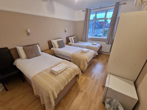 a hotel room with two beds and a window at Kathleen House in Enfield