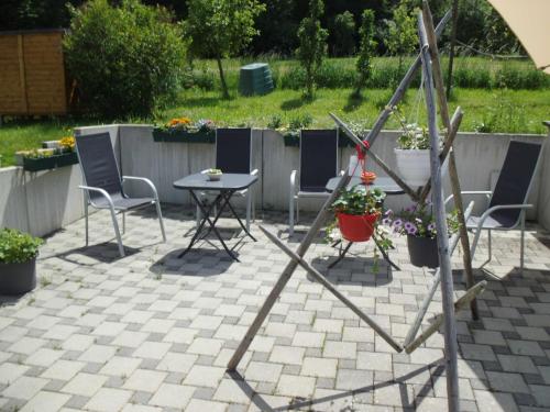 a patio with chairs and a table with flowers at Martini Pension Rammert in Großbettlingen