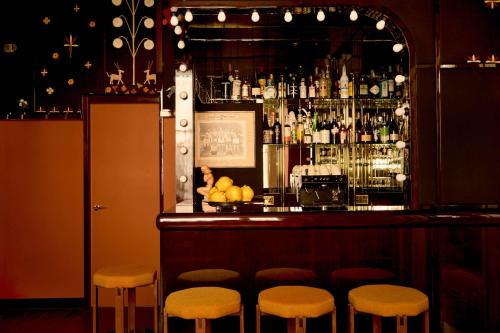 a bar with stools in front of a bar at Grand Hotel Bellevue London in London