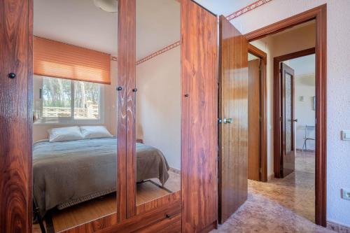 Un dormitorio con una cama y un gran armario de madera. en AT052 Planta baja con piscina, tan solo 600m de la playa, en Torredembarra