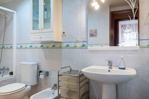 Un baño blanco con lavabo e inodoro. en AT052 Planta baja con piscina, tan solo 600m de la playa, en Torredembarra