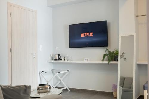 a living room with a tv on a white wall at DIIO Suites in Ermoupoli