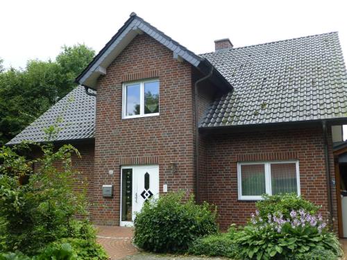 a red brick house with a white door at Ferienwohnung in Tecklenburg