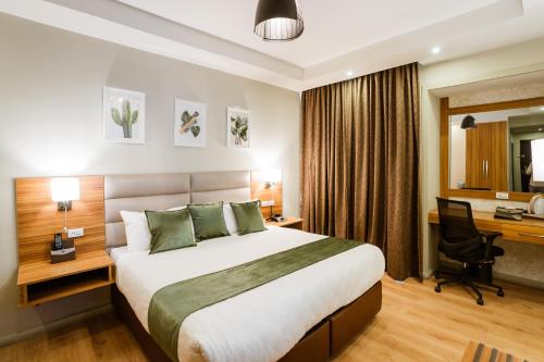 una camera d'albergo con un grande letto e una scrivania di Monarch Hotel ad Addis Abeba