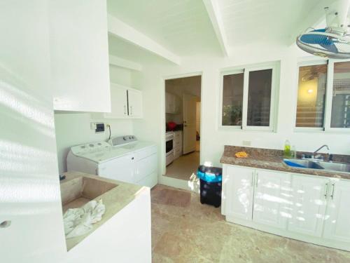 eine weiße Küche mit einer Spüle und einer Theke in der Unterkunft Seasideserenity Luxury Villa Steps From The Beach in La Romana