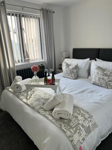 a bed with towels and a tray with bottles of wine at Captains Quarters in Charlestown