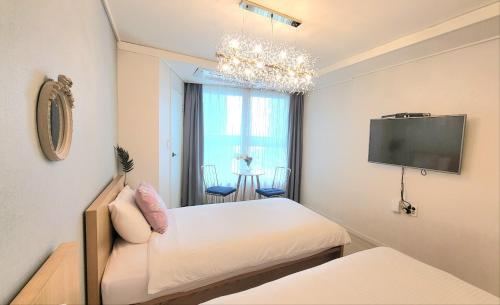 Pokój z łóżkiem i telewizorem z płaskim ekranem w obiekcie Lavender House-IRUA w Pusanie