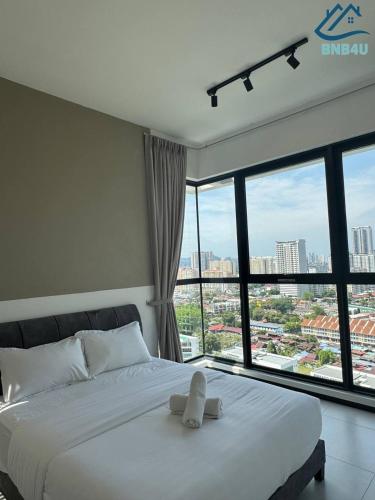 a bedroom with a white bed with a large window at Urban Suites @ George Town Penang by BNB4U in George Town
