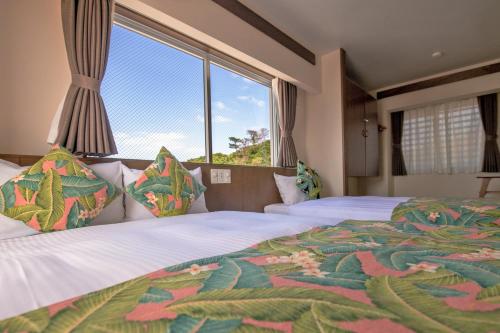 a bedroom with two beds and a large window at Aqua Resort in Chatan in Chatan
