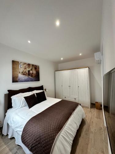 ein Schlafzimmer mit einem großen Bett und einem TV in der Unterkunft Tan-Nanniet Two Bedroom Apartment in Marsaxlokk