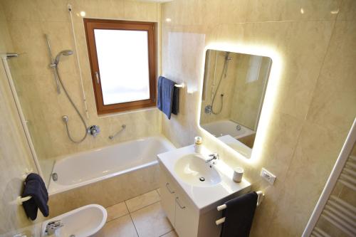 bagno con lavandino, vasca e specchio di T&B MOUNTAIN VIEW a Monguelfo