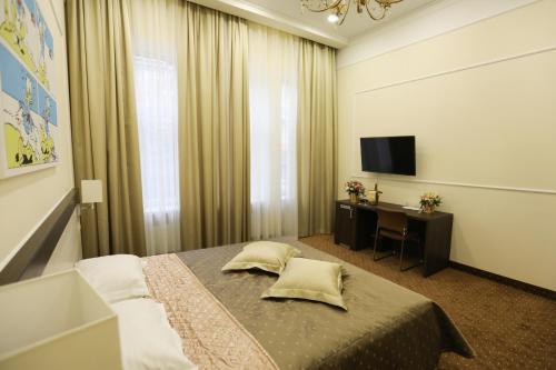 a bedroom with a bed and a desk and a television at Hotel Donald in Odesa