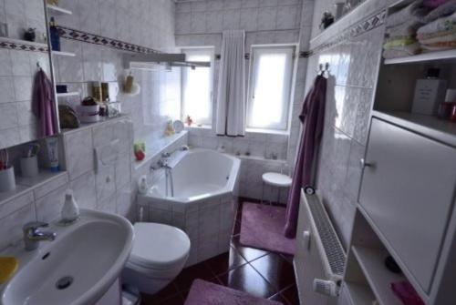 La salle de bains est pourvue d'un lavabo, d'une baignoire et de toilettes. dans l'établissement Ferienwohnung Lindow Mark, à Lindow