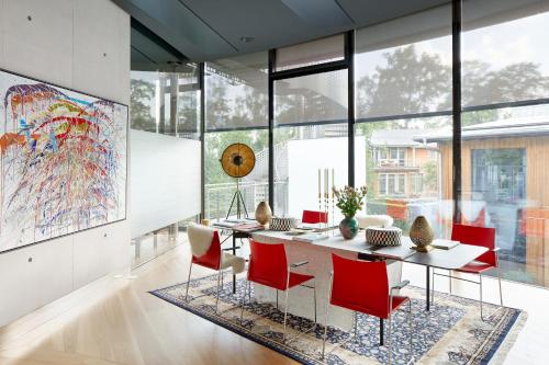 a dining room with a table and red chairs at Ola Residence in Rīga