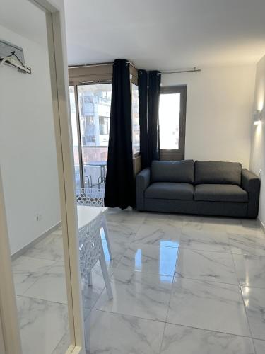 un salon avec un canapé et une fenêtre dans l'établissement Résidence Graziella Appartement 527, à Juan-les-Pins