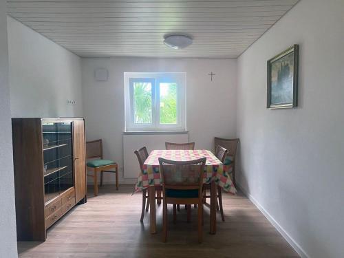 ein Esszimmer mit einem Tisch, Stühlen und einem Fenster in der Unterkunft Eisvogel-Apartment in Rust in Rust