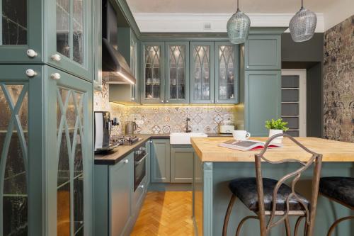 eine Küche mit blauen Schränken und einem Holztisch in der Unterkunft Luxury Apartment with Two Bedrooms and Balcony by Renters Prestige in Krakau