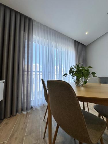 a dining room with a table and chairs and curtains at Tan-Nanniet Two Bedroom Apartment in Marsaxlokk