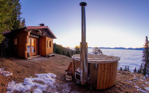 a cabin with a hot tub next to the water at Chalet Petit in Kanzelhöhe