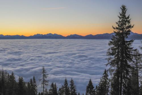 a view from above the clouds at sunset at Chalet Petit in Kanzelhöhe