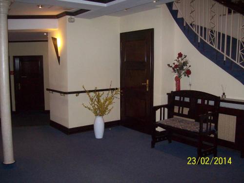 una habitación con un jarrón de flores y una escalera en Hotel Marthahaus, en Halle an der Saale
