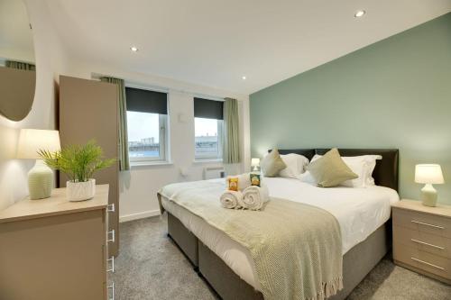 um quarto com uma cama grande com duas toalhas em All Saints Apartments 606 by Week2Week em Newcastle upon Tyne