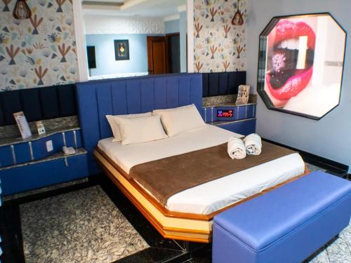 een slaapkamer met een bed en een blauwe muur bij Cartago Hotel in Rio de Janeiro